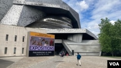 People walk to the Paris Philharmonic, which has kept Russian opera star Anna Netrebko in its 2022 programming. (Lisa Bryant/VOA)