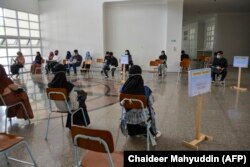 Mahasiswa duduk terpisah untuk menjaga jarak sosial di tengah kekhawatiran COVID-19, sebelum mengikuti ujian perguruan tinggi di Banda Aceh pada 5 Juli 2020. (Foto: AFP/Chaideer Mahyuddin)