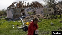 Stanovnica sela Vilhivka, blizu Harkova, pored kuće uništene u ruskom napadu (Foto: REUTERS/Ricardo Moraes)