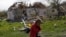 Stanovnica sela Vilhivka, blizu Harkova, pored kuće uništene u ruskom napadu (Foto: REUTERS/Ricardo Moraes)