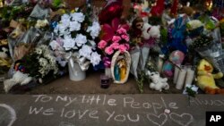 31일 미국 텍사스주 유밸디 롭초등학교 앞 총기난사 희생자 추모 공간 바닥에 애도 메시지가 적혀있다. 