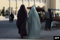 زنان برقع‌پوش افغان در حال قدم زدن در خیابانی در قندهار؛ ٧ مه ٢٠٢٢