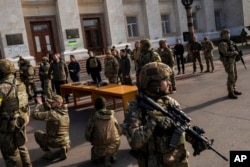 Ukrainian President Volodymyr Zelenskyy guarded by soldiers, gives a speech in Kherson, southern Ukraine, Nov. 14, 2022.