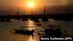 Kapal wisata yang digunakan para wisatawan ditambatkan saat matahari terbenam di sebuah dermaga di Pulau Serangan, Bali pada 6 Agustus 2021, sebagai ilustrasi. (Foto: AFP/Sonny Tumbelaka)