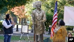 Jesse Tarango, left, chairman of Wilton Rancheria tribe, and his mother, Mary Tarango, look at an enlarged photo of a statue of the late William Franklin Sr. during a groundbreaking ceremony for a Native American monument at Capitol Park in Sacramento, Calif., Nov. 14, 2022. 