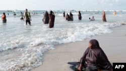 Seorang perempuan tampak duduk bersantai di pantai Lido di Mogadishu, Somalia, pada 11 November 2022. (Foto: AFP/Guy Peterson)