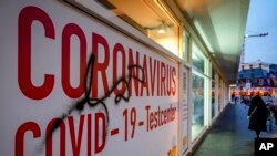 A woman walk next to an abandoned COVID-19 testing center in Frankfurt, Germany, Nov. 2, 2021