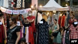 FILE - People shop for wholesale clothing at Pratunam Market in Bangkok on March 2, 2016.