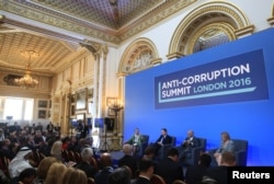 From left, Sarah Chayes from the Carnegie Endownment for International Peace,British Prime Minister Cameron, Afghan President Ghani and French magistrate Eva Jolly share a platform at the international anti-corruption summit, London, Britain, May 12, 2016.