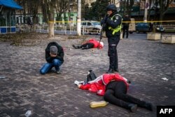 A man reacts next a body of a dead woman after Russian shelling hit the southern Ukrainian city of Kherson, Dec. 24, 2022.