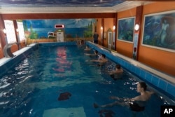 Ukrainian soldier take part in an aquatic therapy session in a hot pool at a rehabilitation center in Kharkiv region, Ukraine, Friday, Dec. 30, 2022. (AP Photo/Vasilisa Stepanenko)