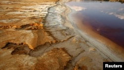 FILE - Polluted water emanating from mining operations fills a dam near Johannesburg, South Africa, Sept. 24, 2015. 