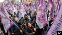 Kurdish activists hold flags during a march to honor three women Kurdish activists who were shot dead in 2013, Dec. 26, 2022 in Paris.