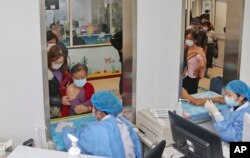 Elderly residents gets vaccinated against COVID-19 at a community health center in Nantong in eastern China's Jiangsu province on Dec. 9, 2022. (Chinatopix Via AP)