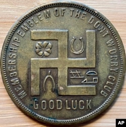 محقق جیف کلیمن کے پاس نازی پارٹی کے قیام سے پہلے کا ایک اسٹور ٹوکن ہے جس پر سواستیکا کا نشان بنا ہوا ہے۔ (فوٹو، اےپی)