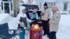 A group of neighbors gather around a fire pit on Culver Road after clearing snow in Buffalo, New York, Dec. 26, 2022. The region is digging out from a pre-Christmas blizzard that delivered hurricane-force winds and more than 4 feet of snow. 