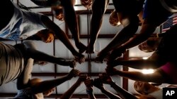 Fisk University gymnastics team gathers in a circle for a cheer during practice at the Nashville Gymnastics Training Center on Dec. 28, 2022, in Nashville, Tenn.