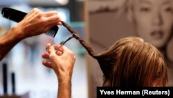 Belgian hairdresser at salon L'Atelier Chedly Boussigua cuts a customer's hair, in Brussels, Belgium November 4, 2022. (REUTERS/Yves Herman)