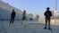 Security officials guard a blocked road leading to a counterterrorism center after security forces started to clear the compound seized earlier by Pakistani Taliban militants in Bannu, Pakistan, Dec. 20, 2022.