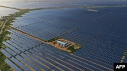 FILE - This photo taken on Oct. 6, 2021 shows solar panels at the site of solar energy projects developer Saurya Urja Company of Rajasthan Limited, in the northern Indian state of Rajasthan. (Photo by Sajjad HUSSAIN / AFP)