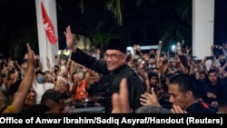 Malaysia's newly appointed Prime Minister Anwar Ibrahim waves to his supporters after his news conference in Sungai Long, Selangor, Nov. 24, 2022. 