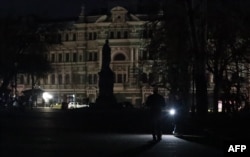 Seorang pria memegang obor listrik saat pemadaman listrik di Kota Odessa, Laut Hitam Ukraina, pada 12 Desember 2022. Dengan suhu yang turun di bawah nol, serangan Rusia yang berulang kali telah membuat jaringan energi Ukraina berada di ambang kehancuran dan mengganggu pasokan listrik dan air ke jutaan orang selama beberapa minggu terakhir. (Foto: AFP/Oleksandr GIMANOV)