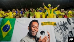 FILE - Brazil fans cheer by a banner celebrating Pele before the World Cup match between Brazil and South Korea at Al Rayyan, Qatar, Dec. 5, 2022.