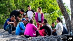 A group of Cuban migrants gather on the side of U.S. 1 in the Middle Keys island of Duck Key, Florida, Jan. 2, 2023.
