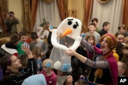 An actress performs for children at the Dzherelo rehabilitation center during celebrations for Saint Nicholas Day, in Kyiv, Ukraine, Monday, Dec. 19, 2022.(AP Photo/Evgeniy Maloletka)
