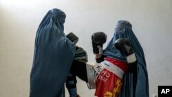 Dua perempuan Afghanistan, yang berlatih Muay Thai, berpose dalam sebuah kesempatan di Kabul, Afghanistan, pada 29 Oktober 2022. (Foto: AP/Ebrahim Noroozi)