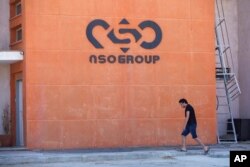 FILE - A logo adorns a wall on a branch of the Israeli NSO Group company, near the southern Israeli town of Sapir, Aug. 24, 2021.