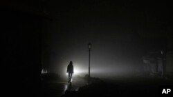 ស្ត្រី​មា្នក់​ដើរ​កាត់​តំបន់​កណ្តាល​ក្រុង​កៀវ ដែល​ដាច់​ចរន្ត​អគ្គិសនី​ក្រោយ​ពី​ត្រូវ​រង​ការ​វាយប្រហារ​រ៉ុក្កែត​រុស្ស៊ី កាល​ពី​ថ្ងៃ​ទី​២៤ ខែ​វិច្ឆិកា ឆ្នាំ​២០២២។