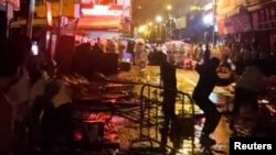 Demonstranti koji protestuju zbog Covid mjera bacaju staklene boce prema policiji za nerede u Guangzhouu, provincija Guangdong, 