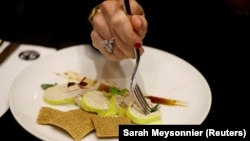 A woman eats 'Faux-gras', a vegan alternative to foie gras, in the restaurant "42 Degres" in Paris France, December 15, 2022. (REUTERS/Sarah Meyssonnier)