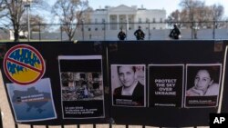 FILE - Signs and pictures of those killed, including journalist Brent Renaud, are displayed on a fence during a protest against Russia's invasion of Ukraine in Lafayette Park near the White House, March 13, 2022, in Washington. 