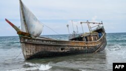 Perahu yang membawa pengungsi tiba di pantai Krueng Raya, Aceh, 25 Desember 2022. (CHAIDEER MAHYUDDIN/AFP)