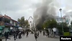 People clash with security forces during a protest in Sweida, Syria, Dec. 4, 2022, in this screen grab obtained from a social media video. (Suwayda 24/via Reuters) 