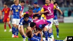 Japan celebrates after defeating Spain 2-1 during the World Cup group E soccer match between Japan and Spain, at the Khalifa International Stadium in Doha, Qatar, Dec. 1, 2022. 