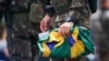 A soldier collects national flags after supporters of former Brazilian former President Jair Bolsonaro left the encampment set up outside army headquarters in Brasilia, Brazil, Jan. 9, 2023.