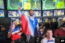 Penggemar sepak bola di Los Angeles, AS, ikut merayakan kemenangan tim AS atas Iran dalam pertandingan sepak bola grup B Piala Dunia Qatar, Selasa, 29 November 2022. (AP Photo/Ringo H.W. Chiu)