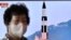 FILE - A woman walks past a television showing a news broadcast with a photo of a Hokkaido missile launch training test by the North Korean People's Army Tactical Nuclear Operation Unit, at a railway station in Seoul, South Korea, Oct. 10, 2022.