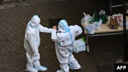 Security guards are seen at the entrance of a compound under COVID-19 lockdown in the Jing'an district in Shanghai on Dec. 3, 2022. 