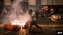Supporters of former President Pedro Castillo clash with riot police during a demonstration demanding his release and the closure of the Peruvian Congress in Lima, on Dec. 11, 2022.