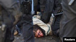 Polisi menahan seorang aktivis selama aksi protes menentang perluasan tambang lignit terbuka Garzweiler milik utilitas RWE Jerman, di Luetzerath, Jerman, Rabu 11 Januari 2023. 