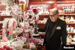Johann Wanner, 83 tahun, produsen hiasan Natal buatan tangan terbesar di dunia, berpose di tokonya Weihnachtshaus (Rumah Natal), di Basel, Swiss, 6 Desember 2022. REUTERS/Denis Balibouse