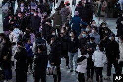 Shoppers return to a popular mall following the easing of pandemic restrictions in Beijing, Sunday, Jan. 1, 2023. (AP Photo/Ng Han Guan)