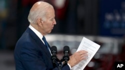 Presiden Joe Biden terlihat sedang membaca dokumen saat berbicara di fasilitas Operasi Powertrain Volvo Group di Hagerstown, Md., Jumat, 7 Oktober 2022. (Foto: AP/Julio Cortez)