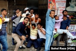 Colleagues look to hail an ambulance to transport two wounded BNP activists to the hospital. The two were among those injured after police opened fire on protesters, in Dhaka, Bangladesh, Dec. 7, 2022.