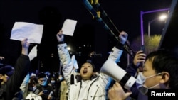 2022年11月28日，在新冠病毒疫情持续扩散之际，北京民众为乌鲁木齐火灾遇难者守夜后，举着白纸抗议中共当局的封控限制。