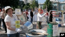 FILE - Protesters, critical of the government's handling of the economy, are seen banging on empty barrels as they rally in downtown Kyiv, Ukraine, May 21, 2015.